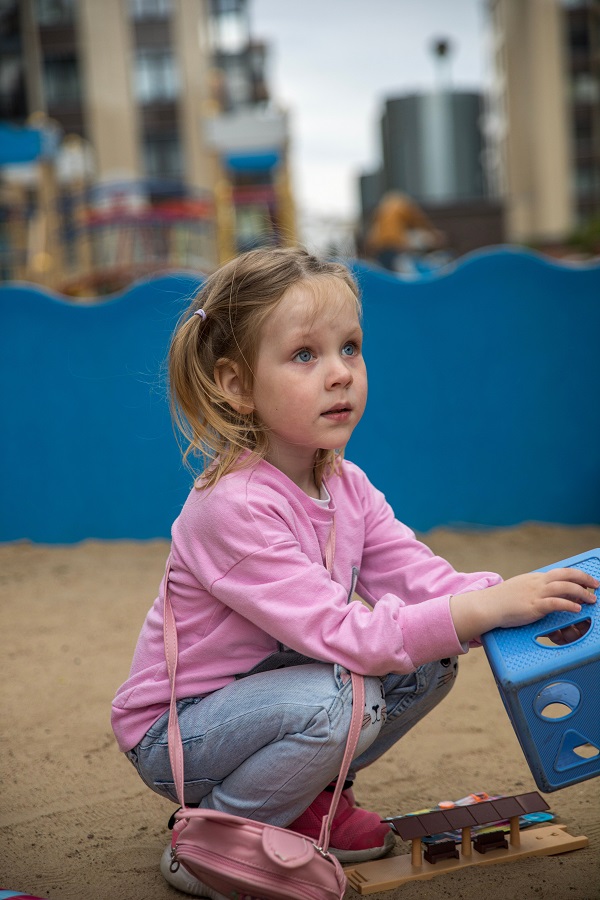 petite fille accroupi dans un jardin d'enfant