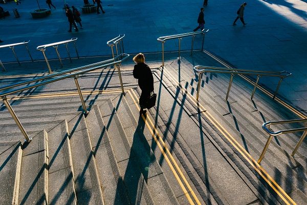 Femme observant plusieurs escaliers avant de choisir le chemin à emprunter.